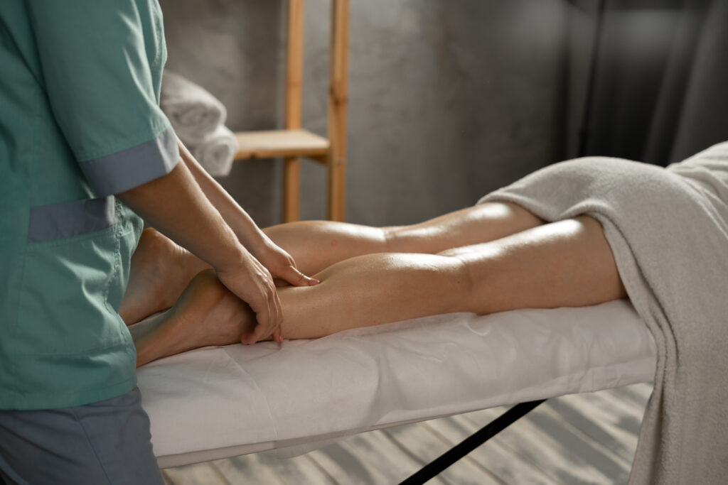 Massage therapist providing circulation and lymphatic micro massage for legs