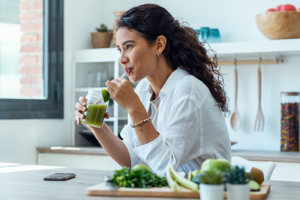 Woman drinking healthy juice to improve micronutrient intake